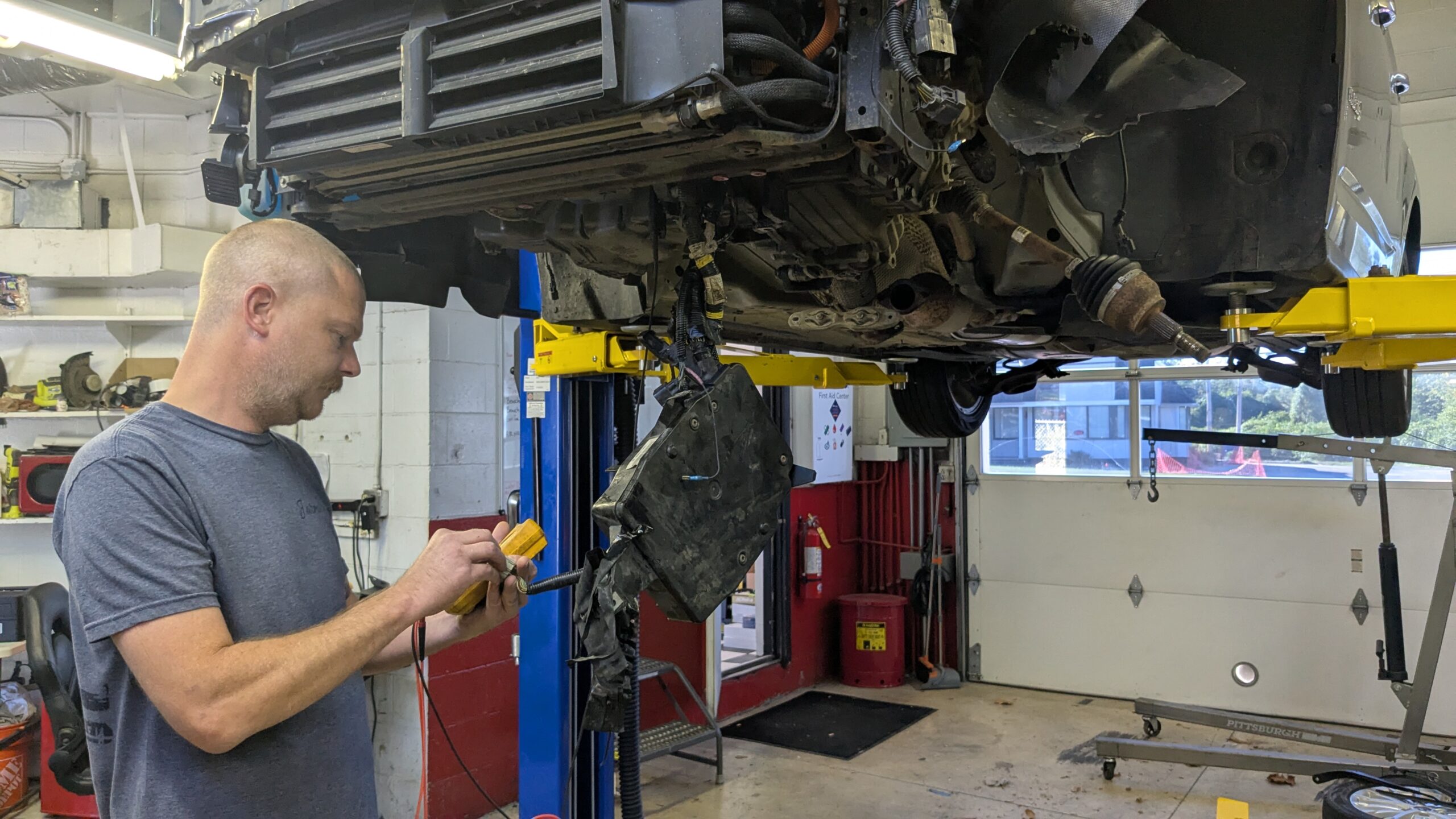 Two car service workers examining vehicle body for scratches and damages while taking a car for professional automotive detailing
